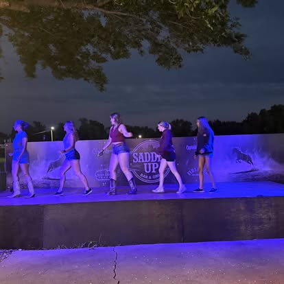 Line dancing on the outdoor stage at night